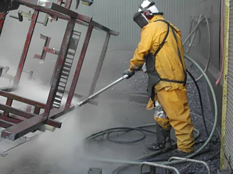 A worker using a Metco distributed Jetstream product to clean industrial equipment