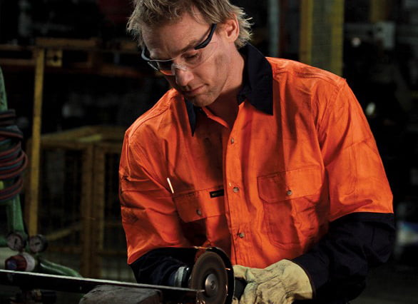 Model wearing workforce safety shirt, gloves, and goggles